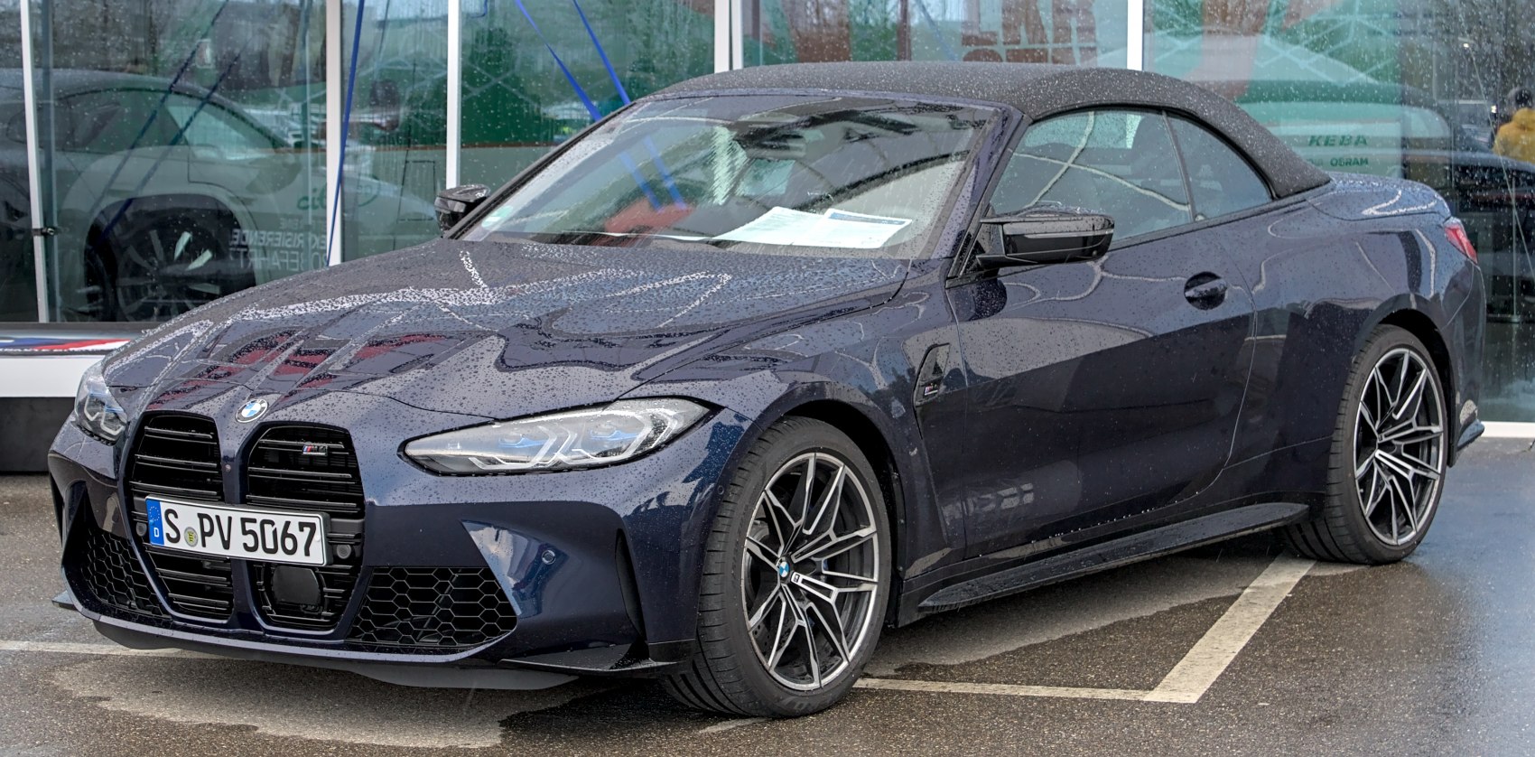 Front side view of convertible with closed soft top and distinctive grille