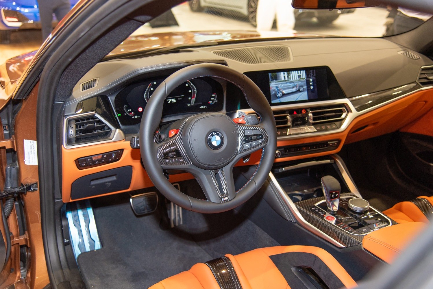 Sporty steering wheel with digital dashboard and orange leather seats