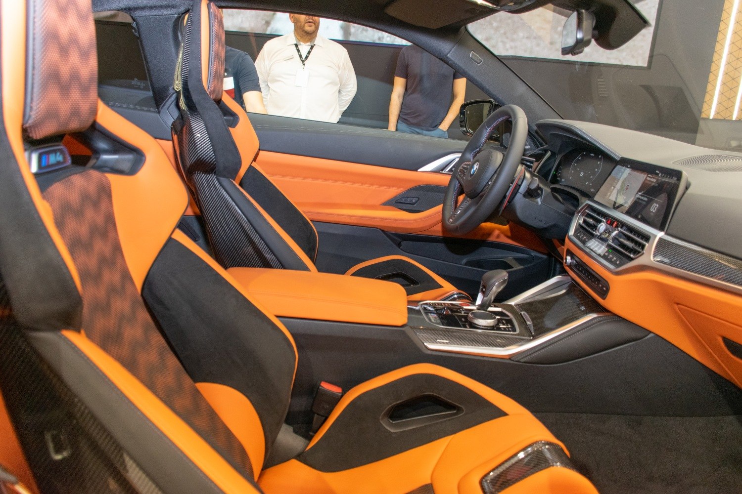Orange and black sport seats with carbon fiber detail and modern digital dashboard