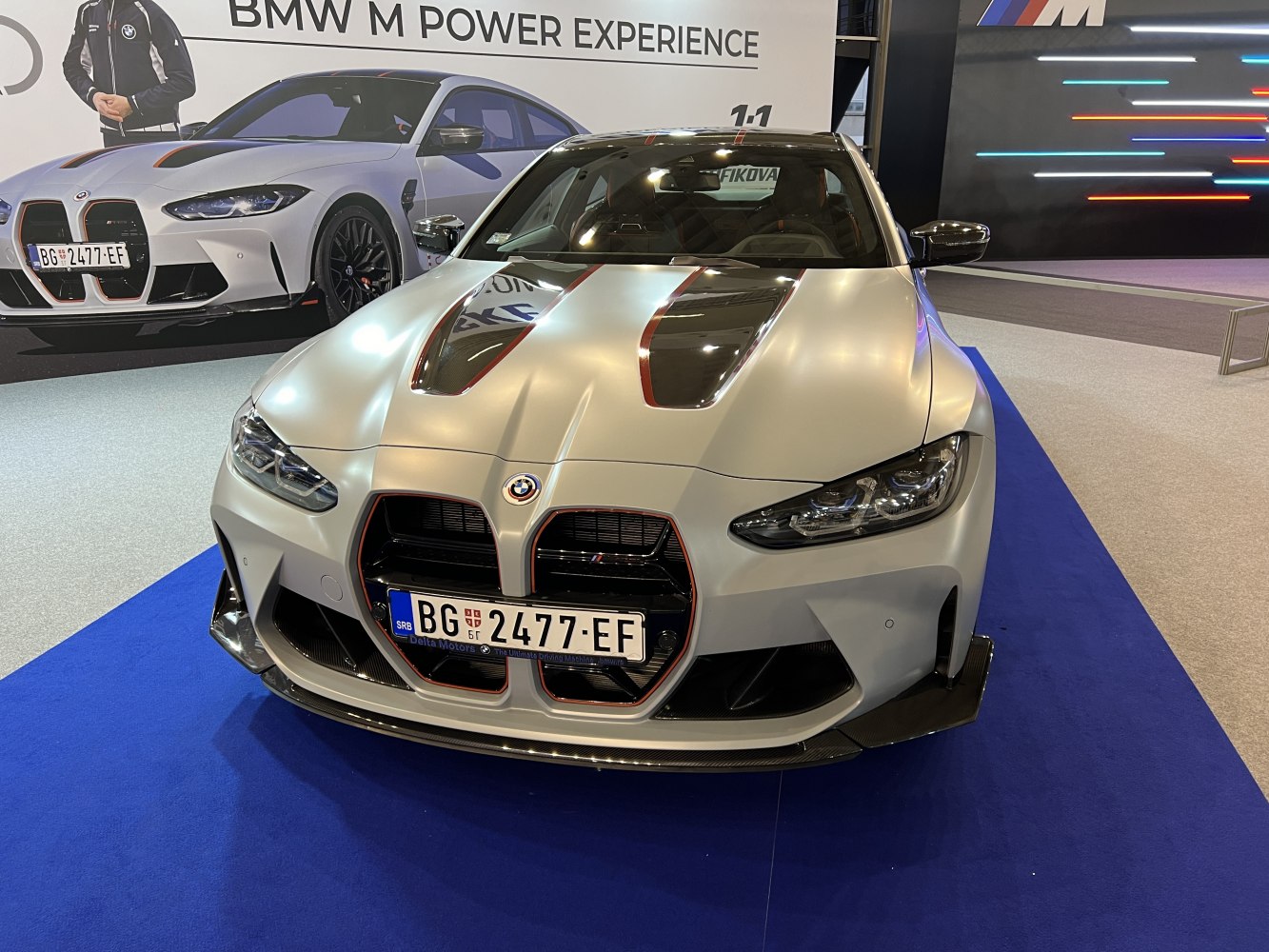 Aggressive front view with carbon fiber hood vents and large grille