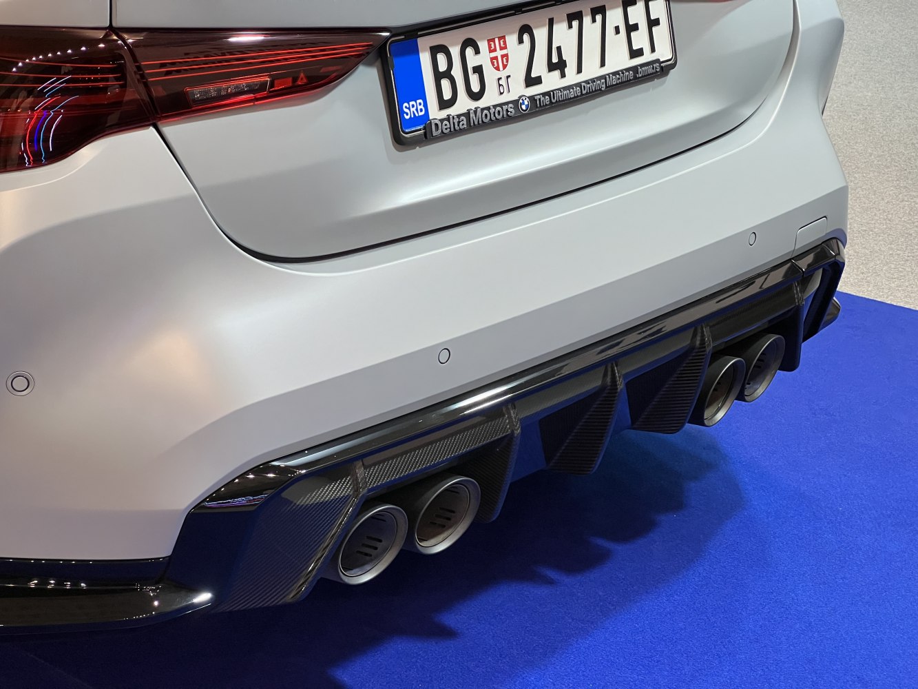 Car's rear with quad exhaust pipes and carbon fiber diffuser.