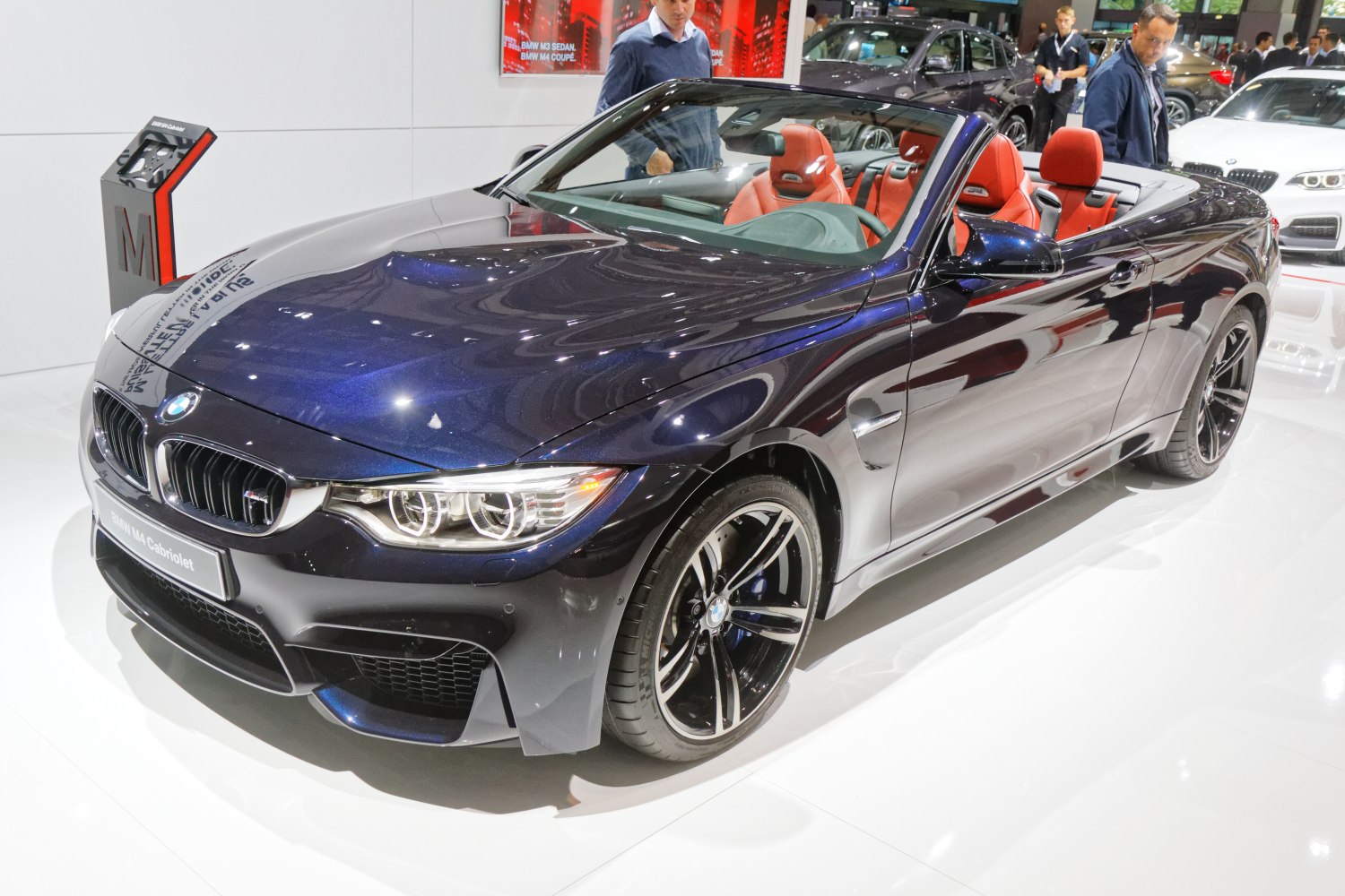 BMW convertible with open roof, red leather seats, and sporty front design