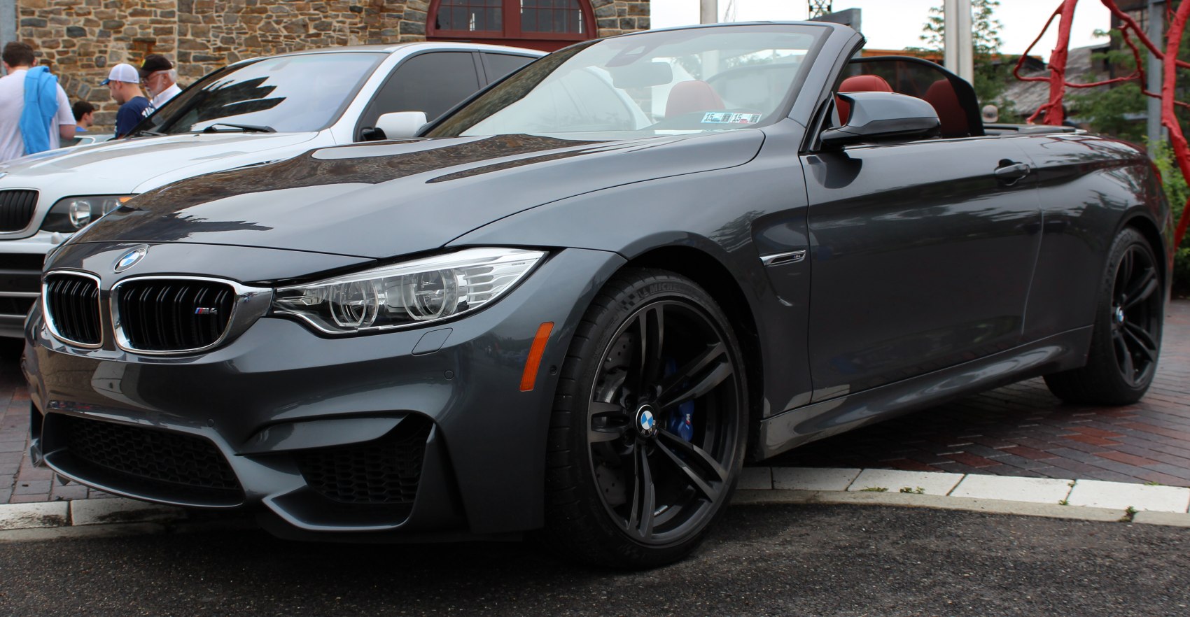 Front view showing sharp headlights and black alloy wheels with brakes