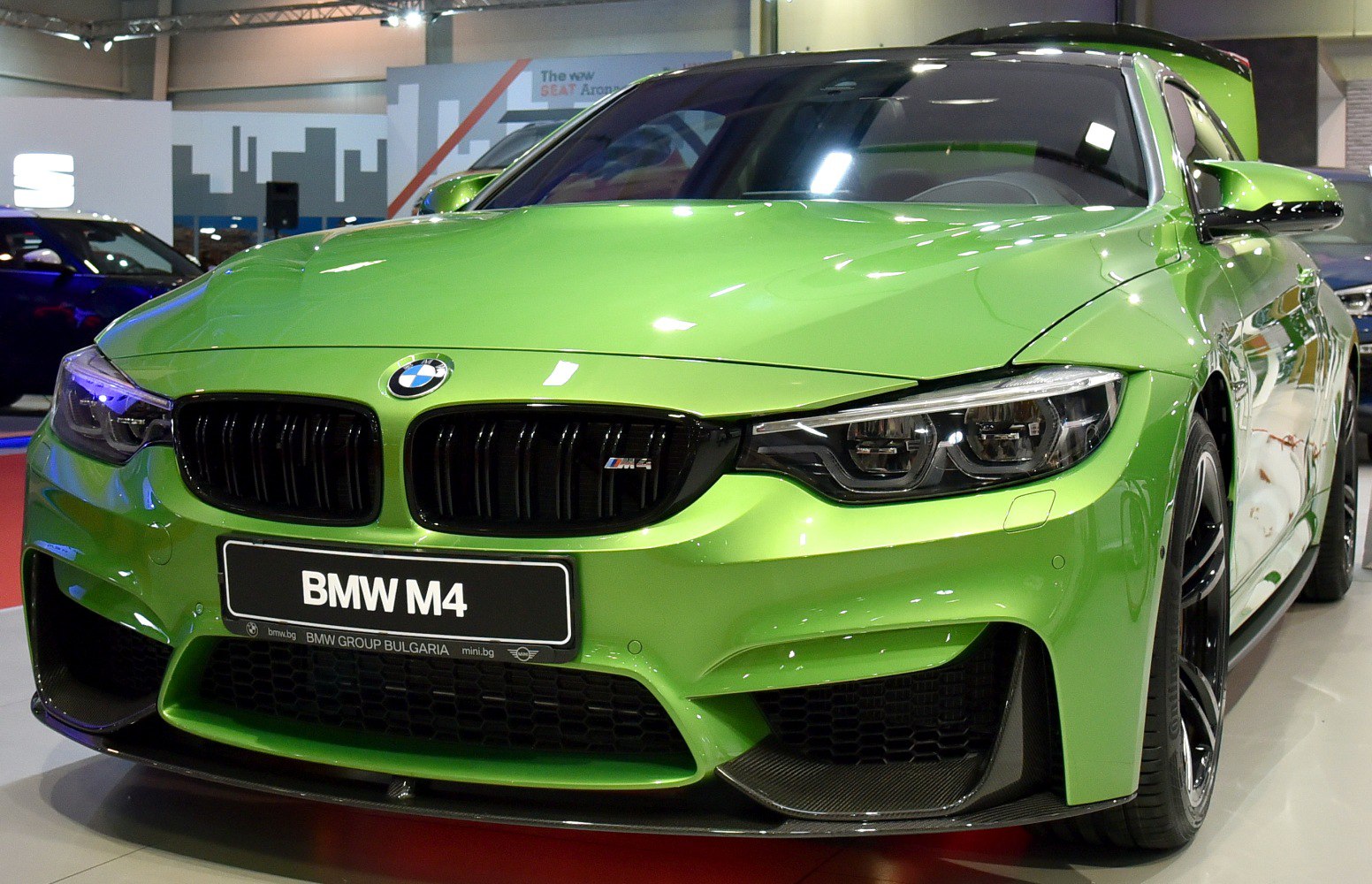 Close-up of BMW M4 front grille and LED headlights in green