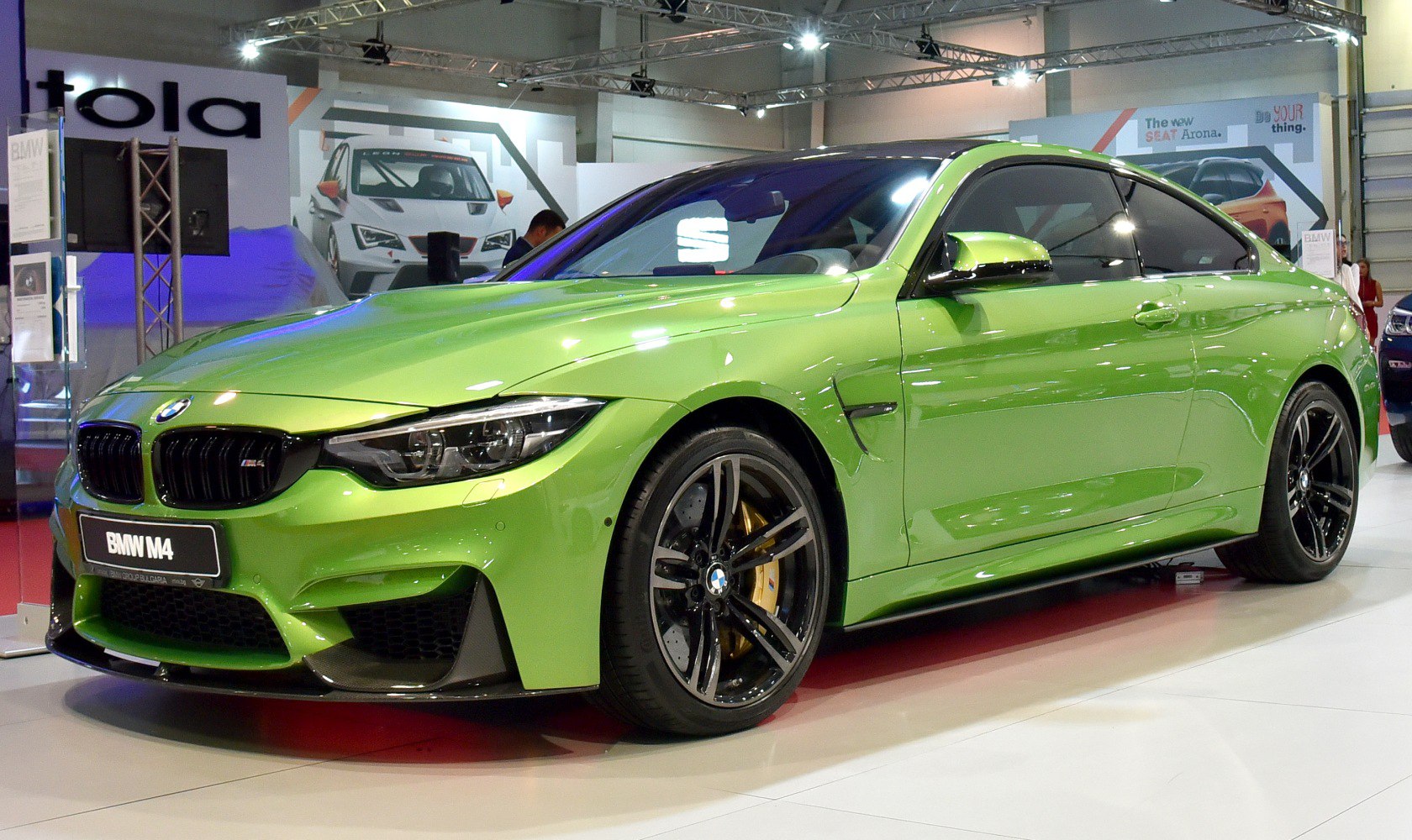 Two-door green sports coupe with large alloy wheels and carbon fiber accents
