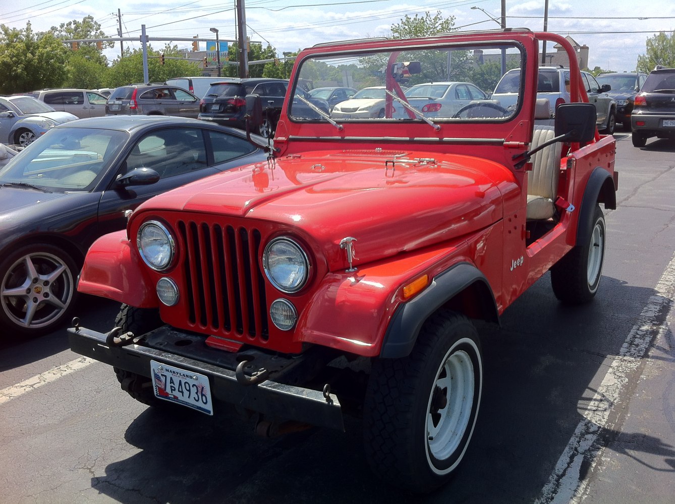 Red vintage vehicle with distinctive grille and open roof