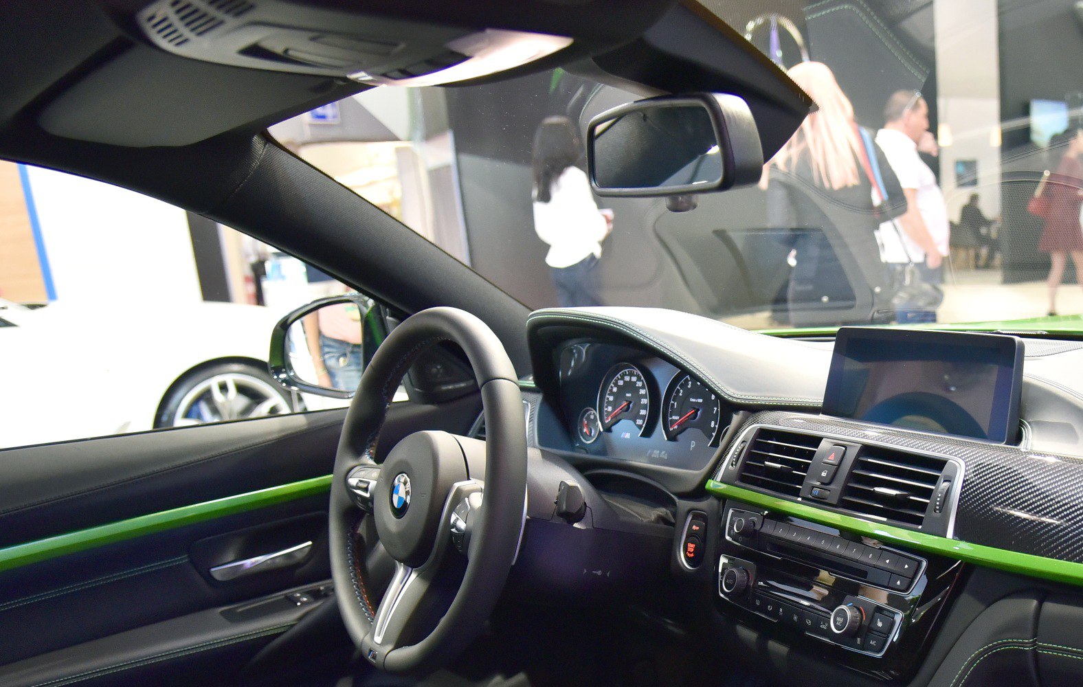 Steering wheel and dashboard with infotainment screen in modern car interior.