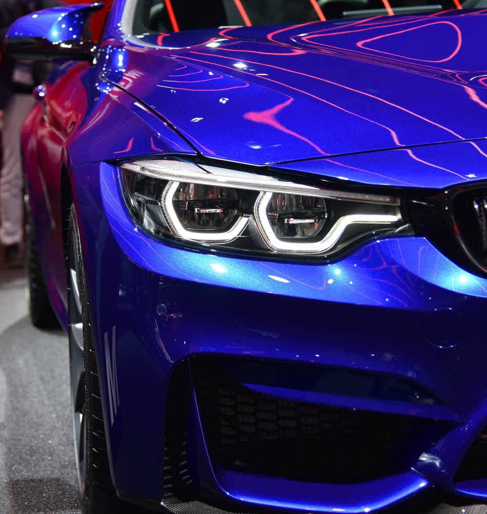 Close-up of front headlight and fender with sharp LED lights in blue.