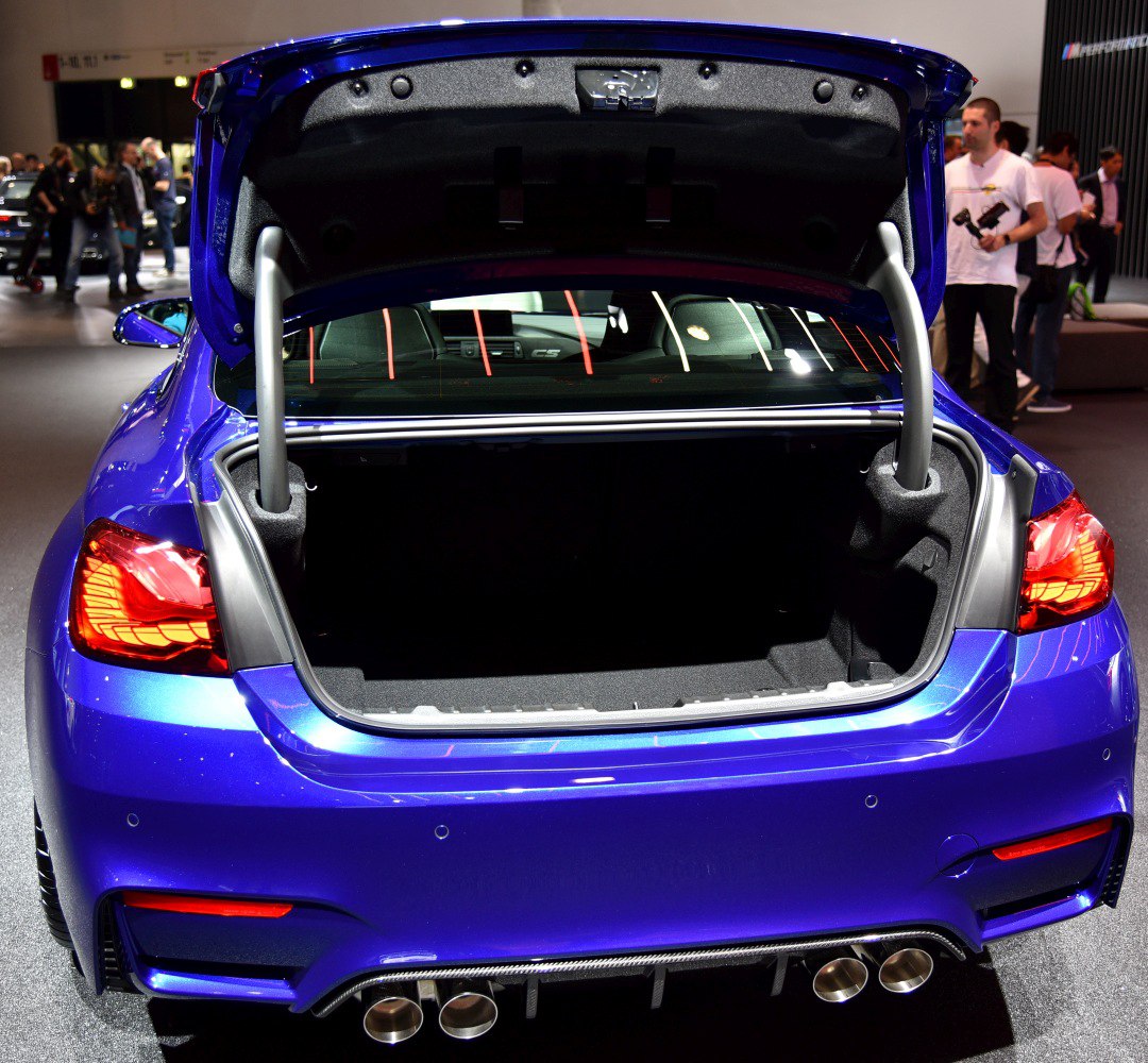 Open trunk with visible spacious cargo area and quad exhaust pipes.