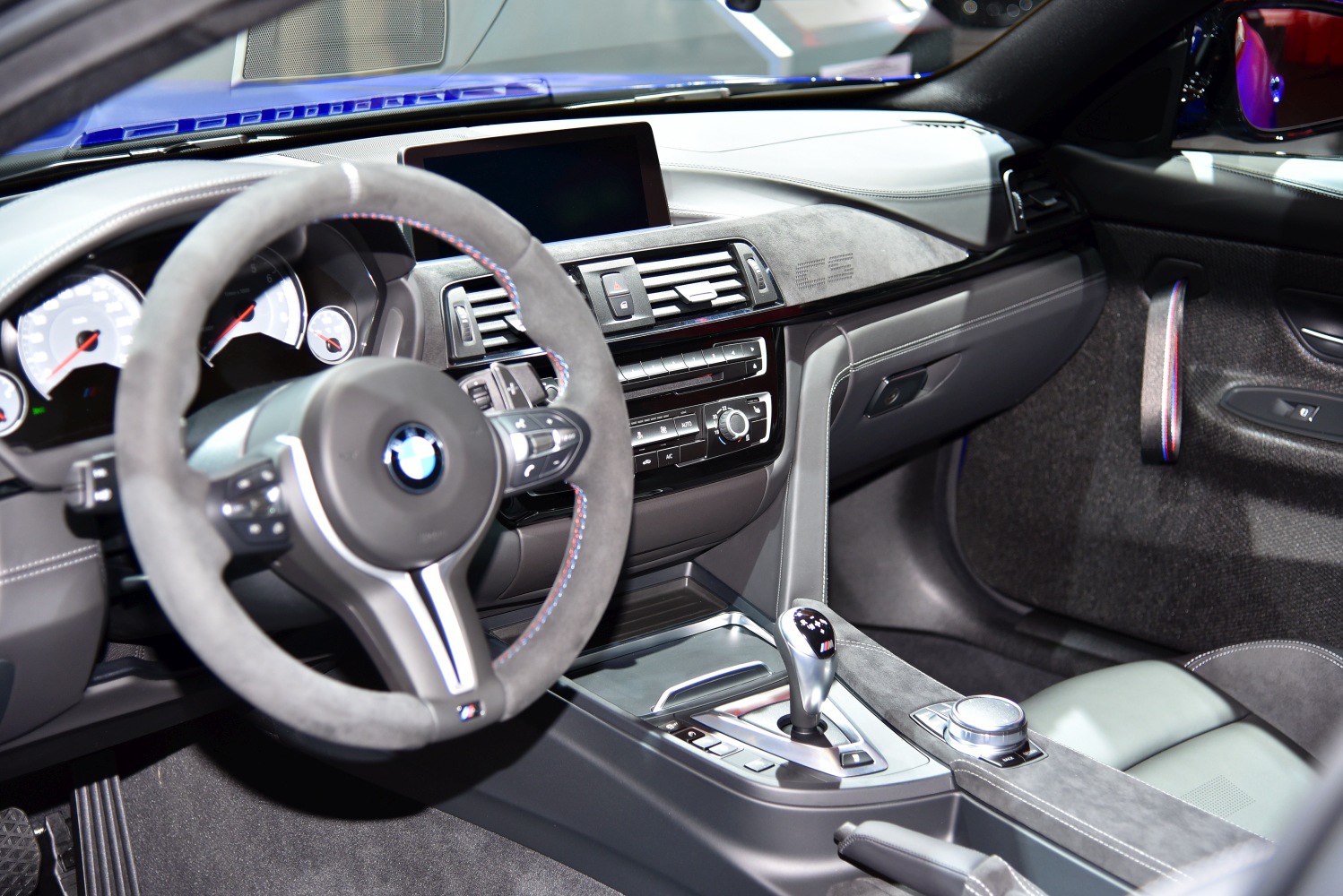 Alcantara-wrapped steering wheel and modern gear shifter on sleek sports car interior