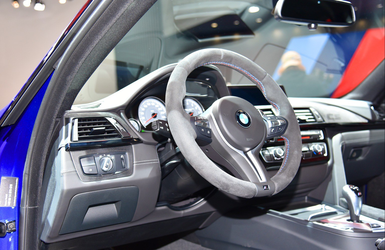 Alcantara steering wheel and dashboard controls in modern car interior