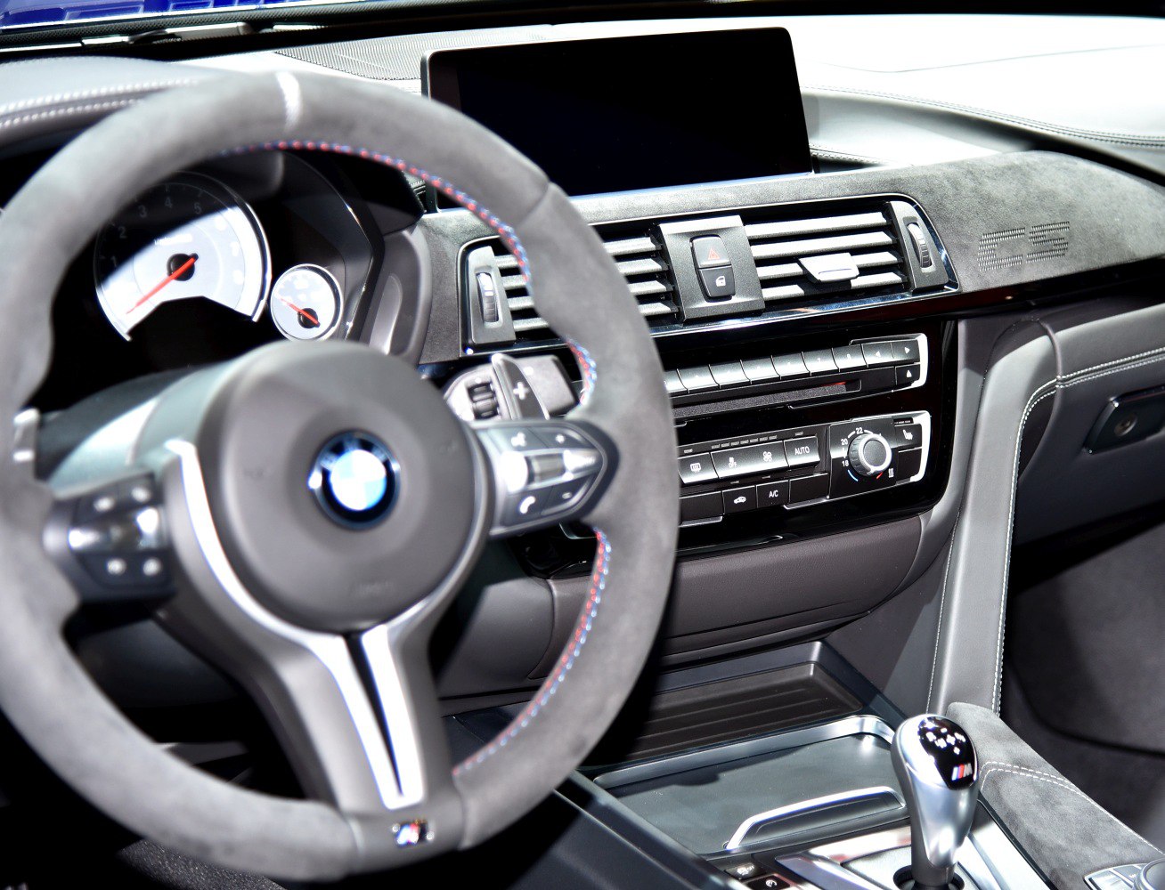 Close-up of steering wheel, dashboard, and gear shifter interior elements