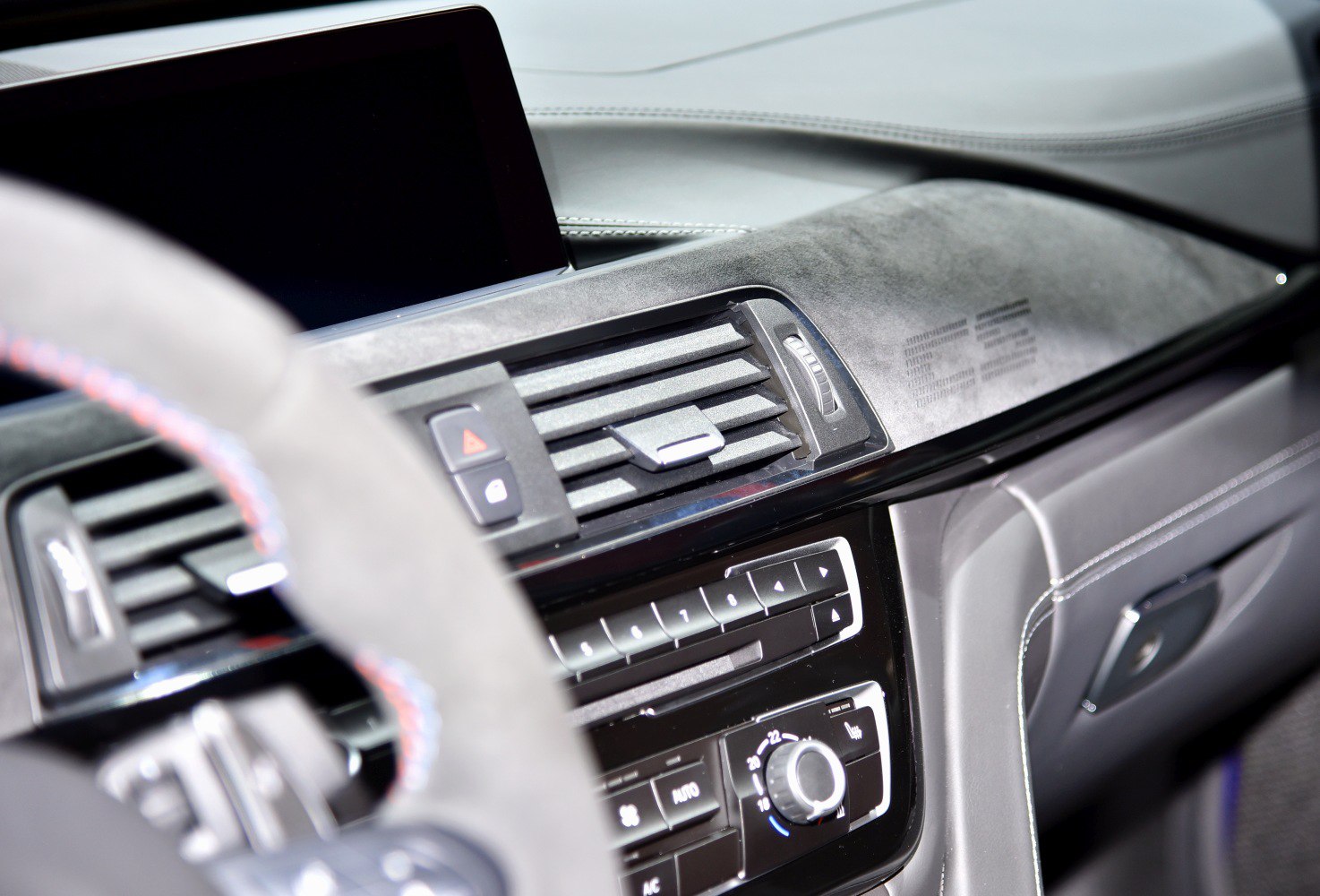 Dashboard air vents and control panel with climate controls in premium interior.