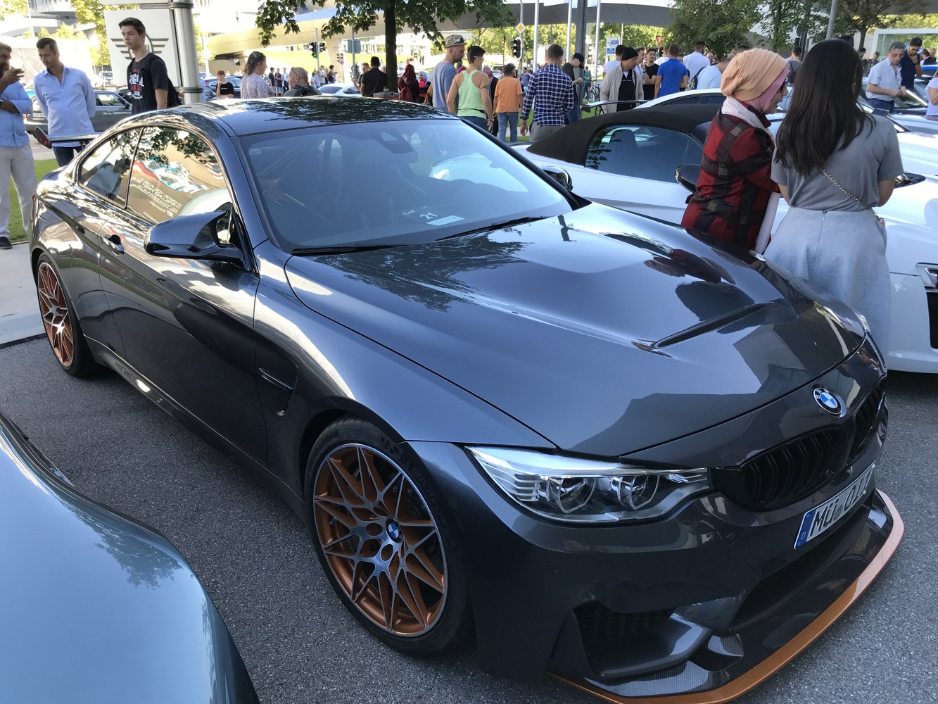 Dark grey sports coupe with bronze multi-spoke wheels and aerodynamic splitter