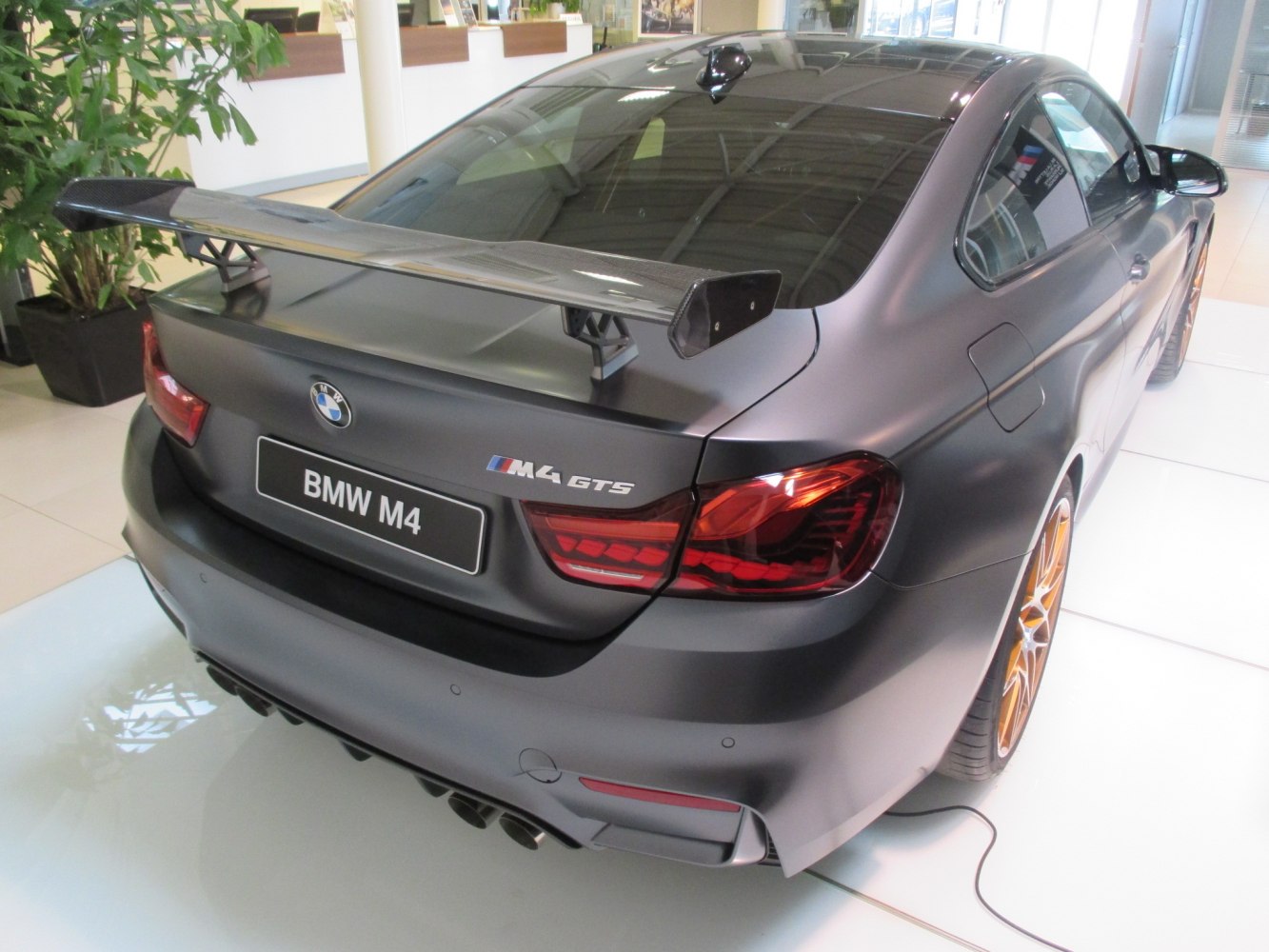 Rear view with carbon fiber spoiler and quad exhaust.