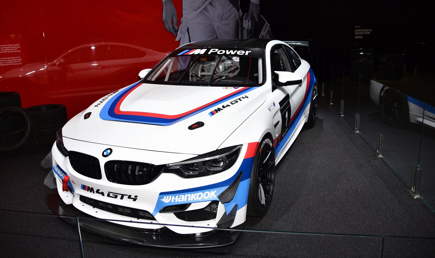 White BMW M4 GT4 race car with M Power livery and aerodynamic racing features