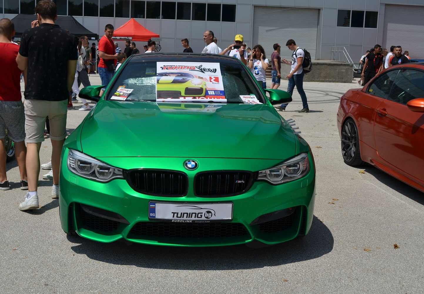 Front view of green sports car with sporty grille and headlights
