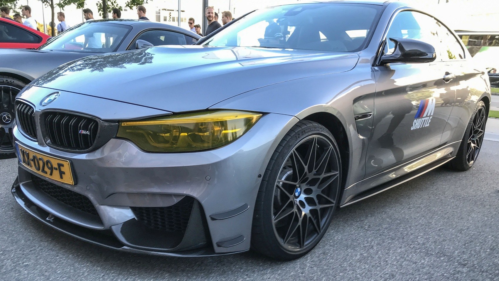Front side view with yellow headlights and black multi-spoke wheels