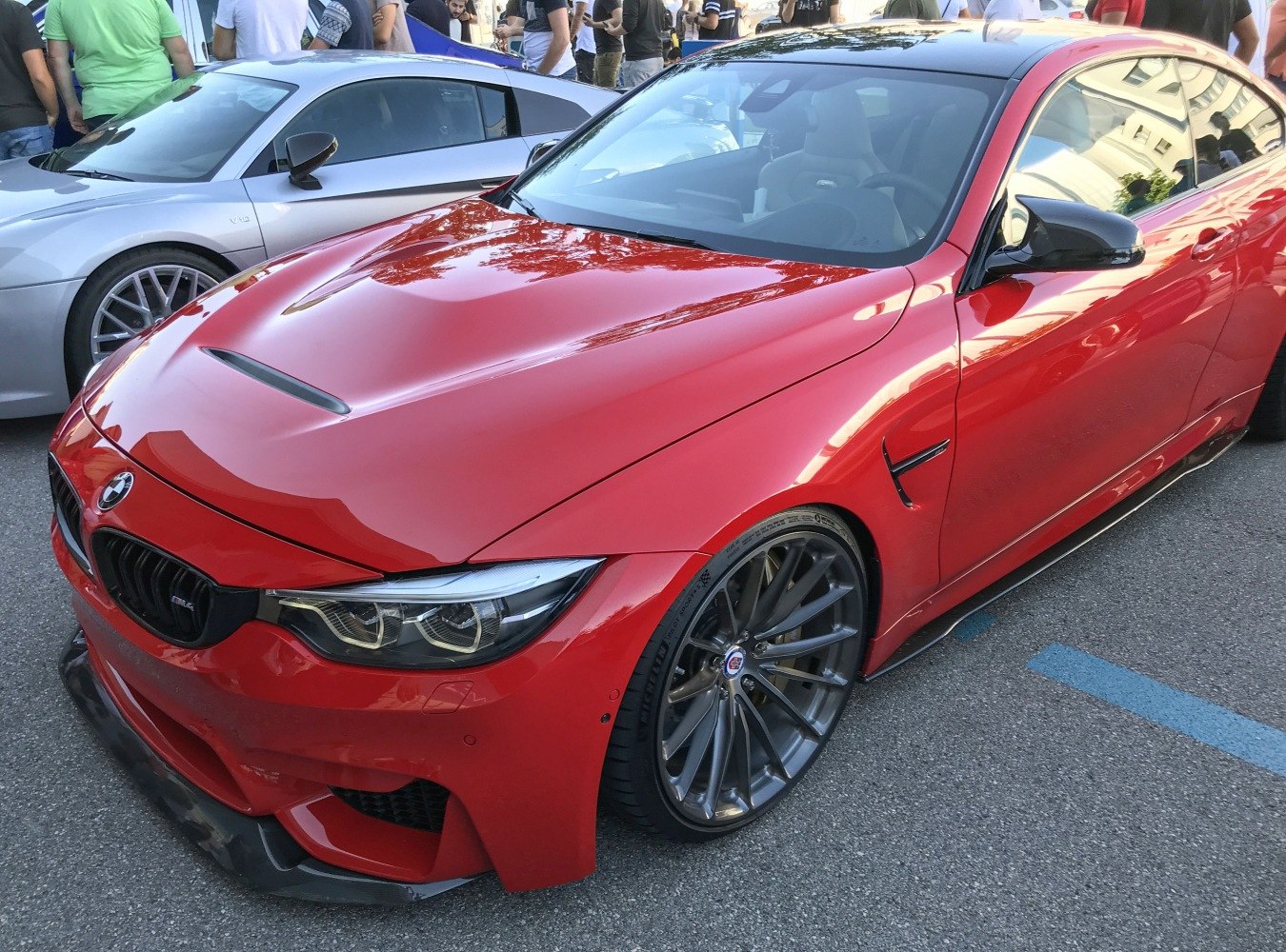 Red sporty coupe with black multi-spoke alloy wheels and front grille