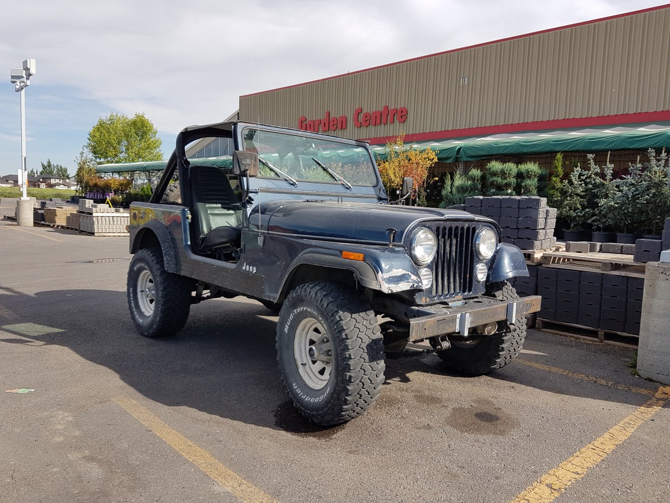 Rugged off-road vehicle with open cabin and round headlights