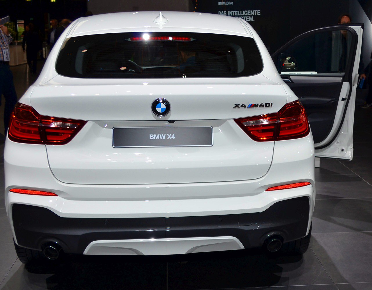 Rear view of white SUV with M40i badge and dual exhausts