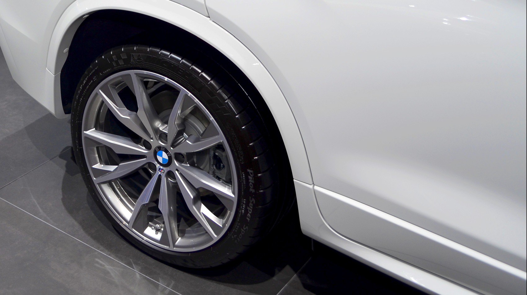 Close-up of alloy wheel and tire on a white vehicle