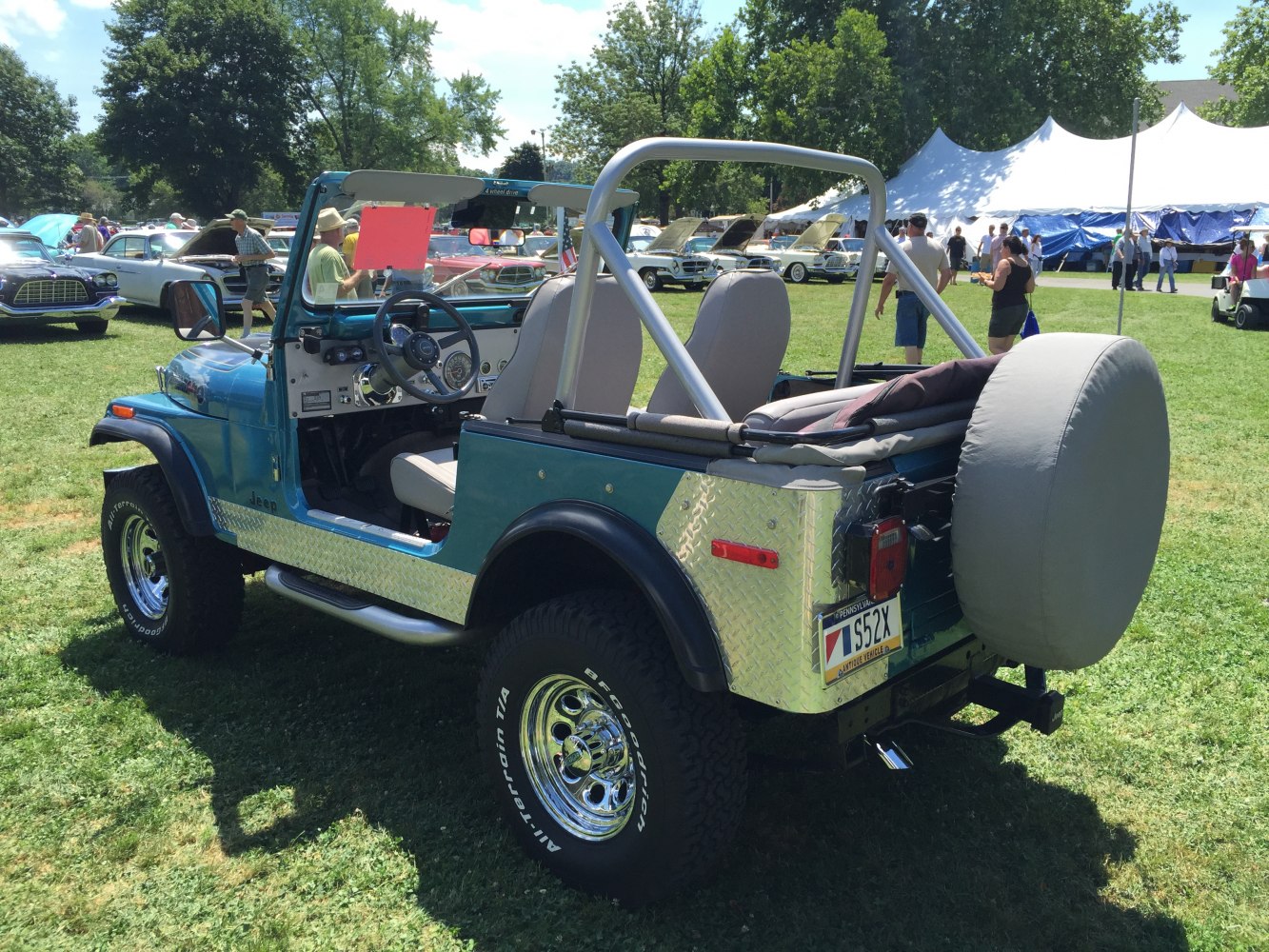 Open-top off-road vehicle with roll cage and spare tire