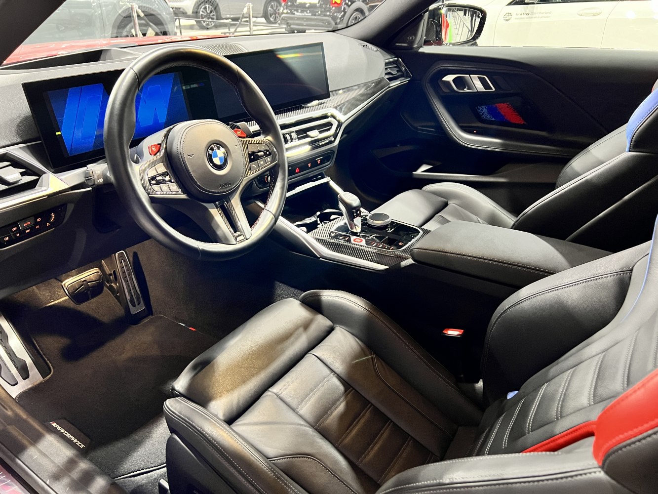 Modern car interior with digital cockpit and carbon fiber trim