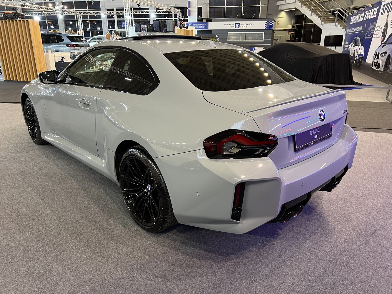 Rear and side view of a sporty coupe with black alloy wheels and a rear spoiler