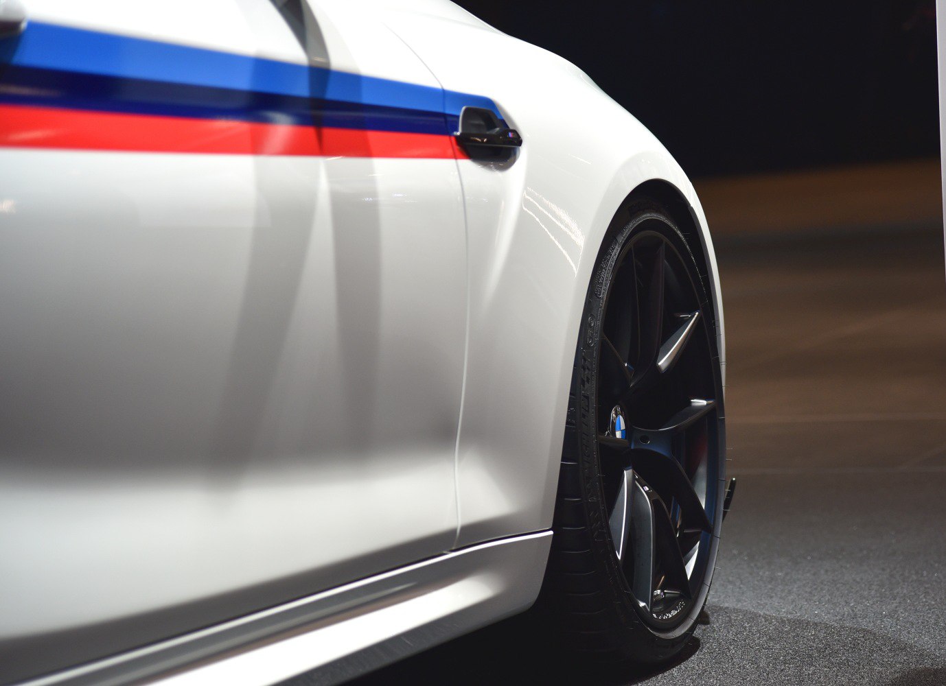 Rear wheel and side panel detail with racing stripes and black alloy wheels