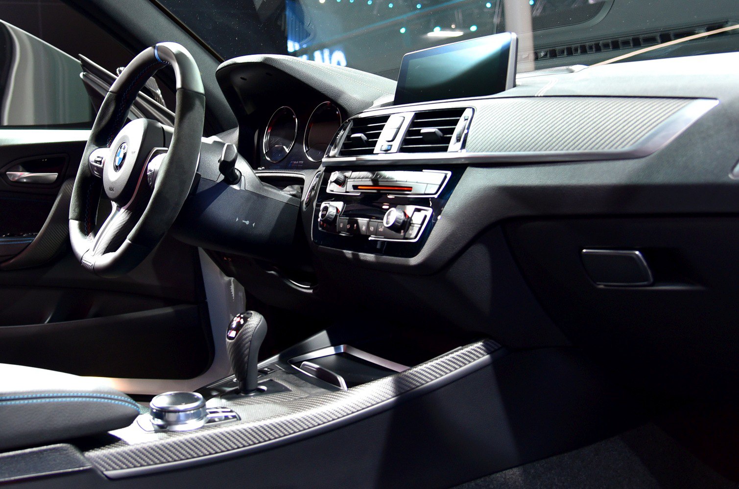 Dashboard and steering wheel with carbon fiber trim and infotainment display