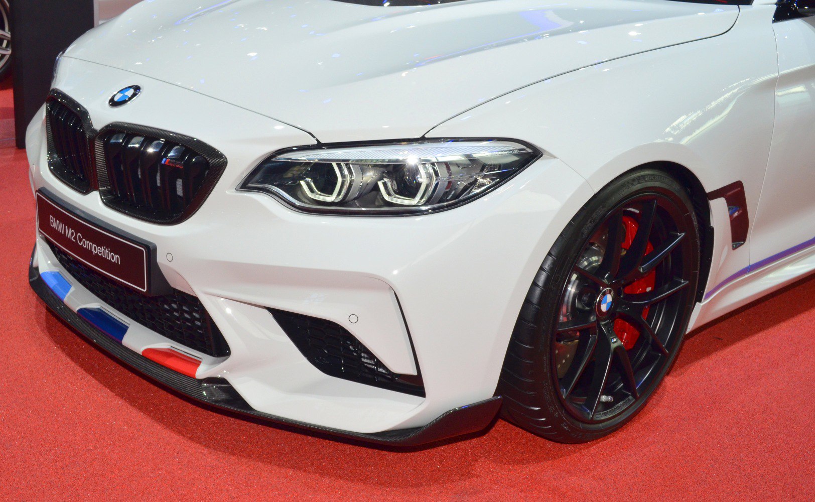 Front end with LED headlights and black alloy wheel with red brake calipers