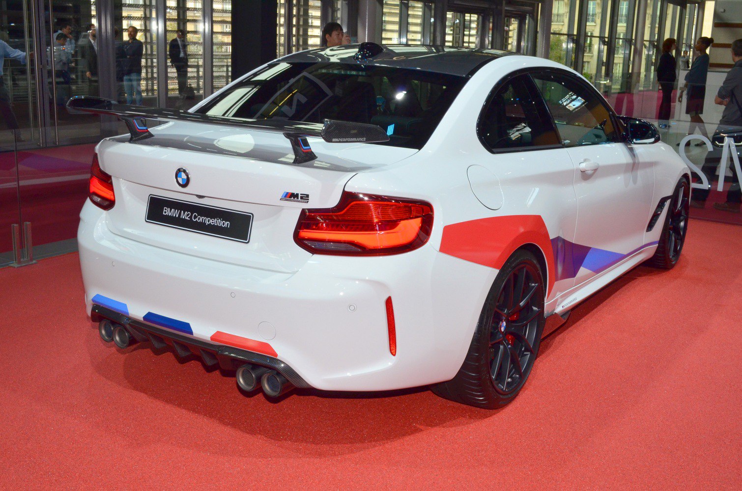Carbon fiber rear wing and quad exhaust of sporty coupe rear