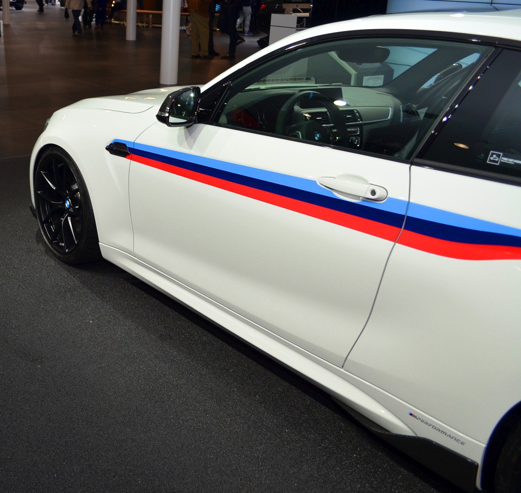 BMW coupe side door with M-striped decal and black alloy wheel