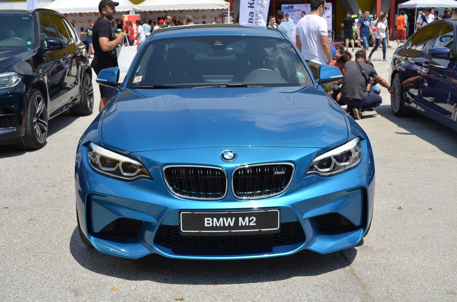 Front view of blue sports coupe with aggressive grille and headlights