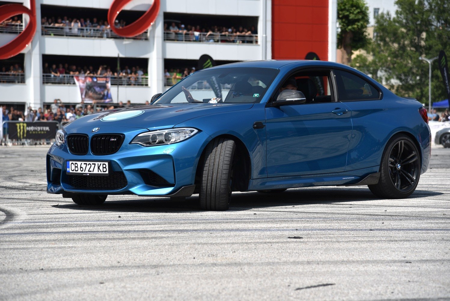 Sporty coupe front angle showing aggressive fascia and black alloy wheels