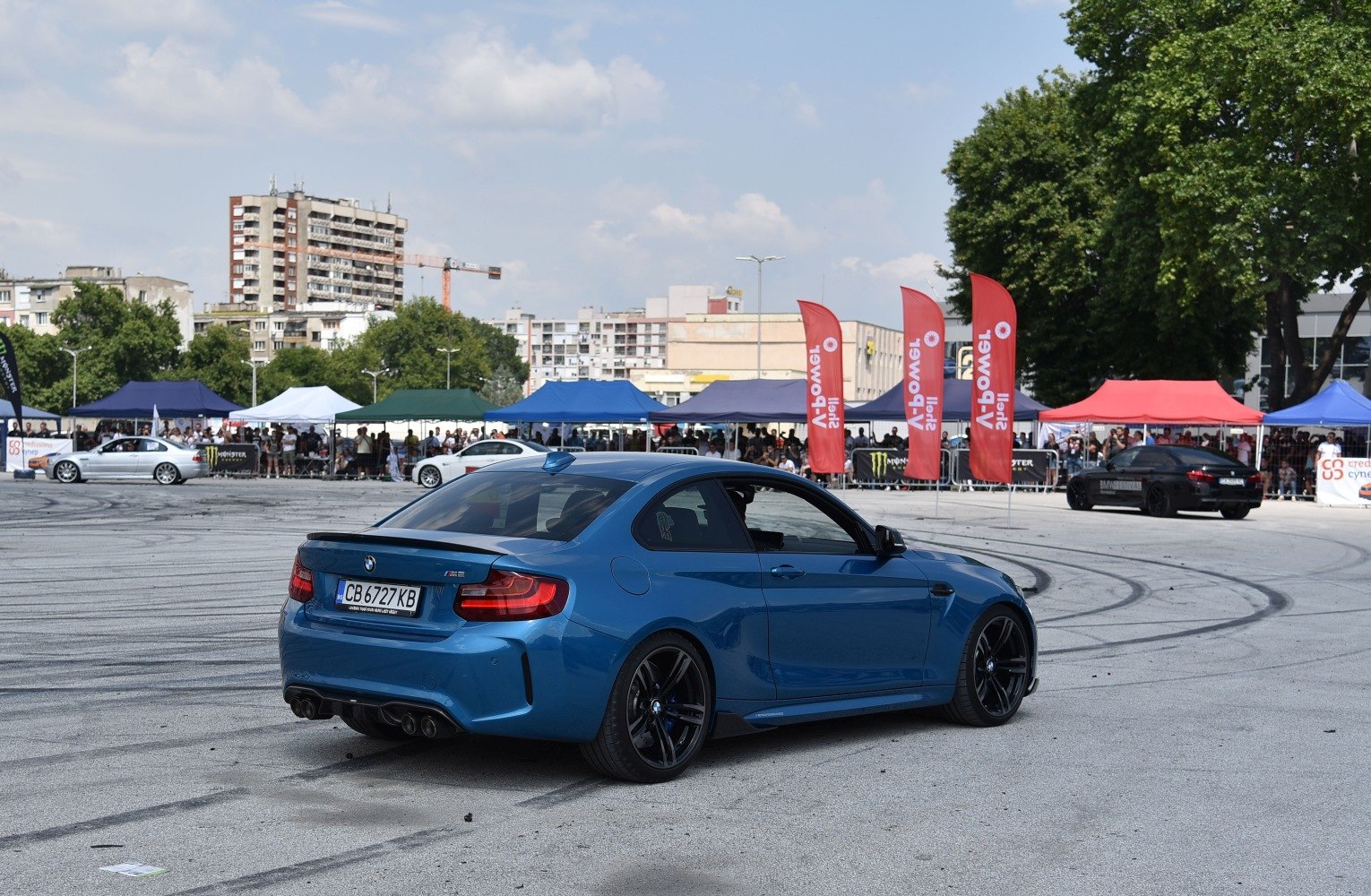 Rear side view of blue coupe with quad exhaust and sporty wheels