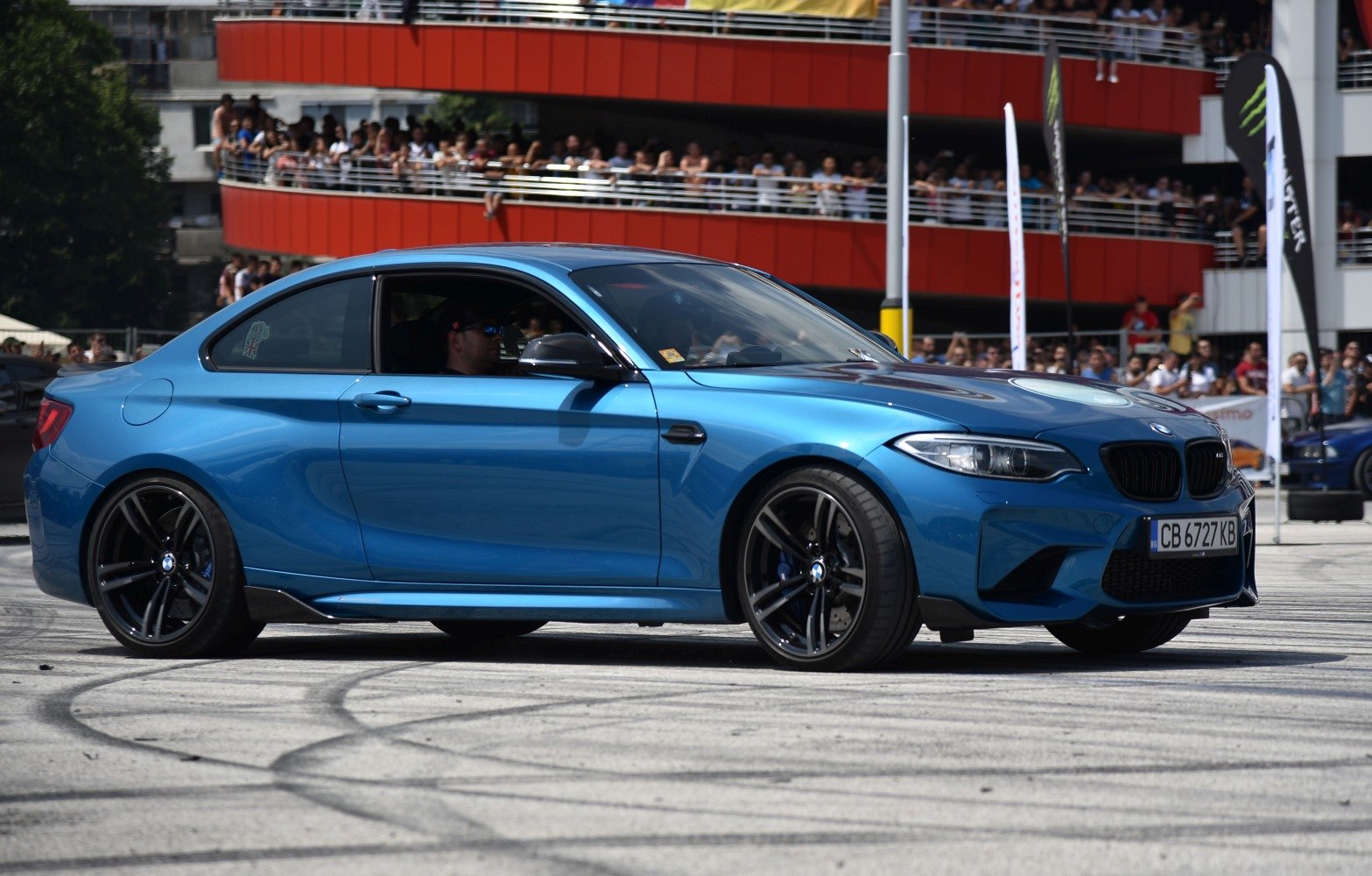 Side view of blue sporty coupe with black wheels and aggressive design