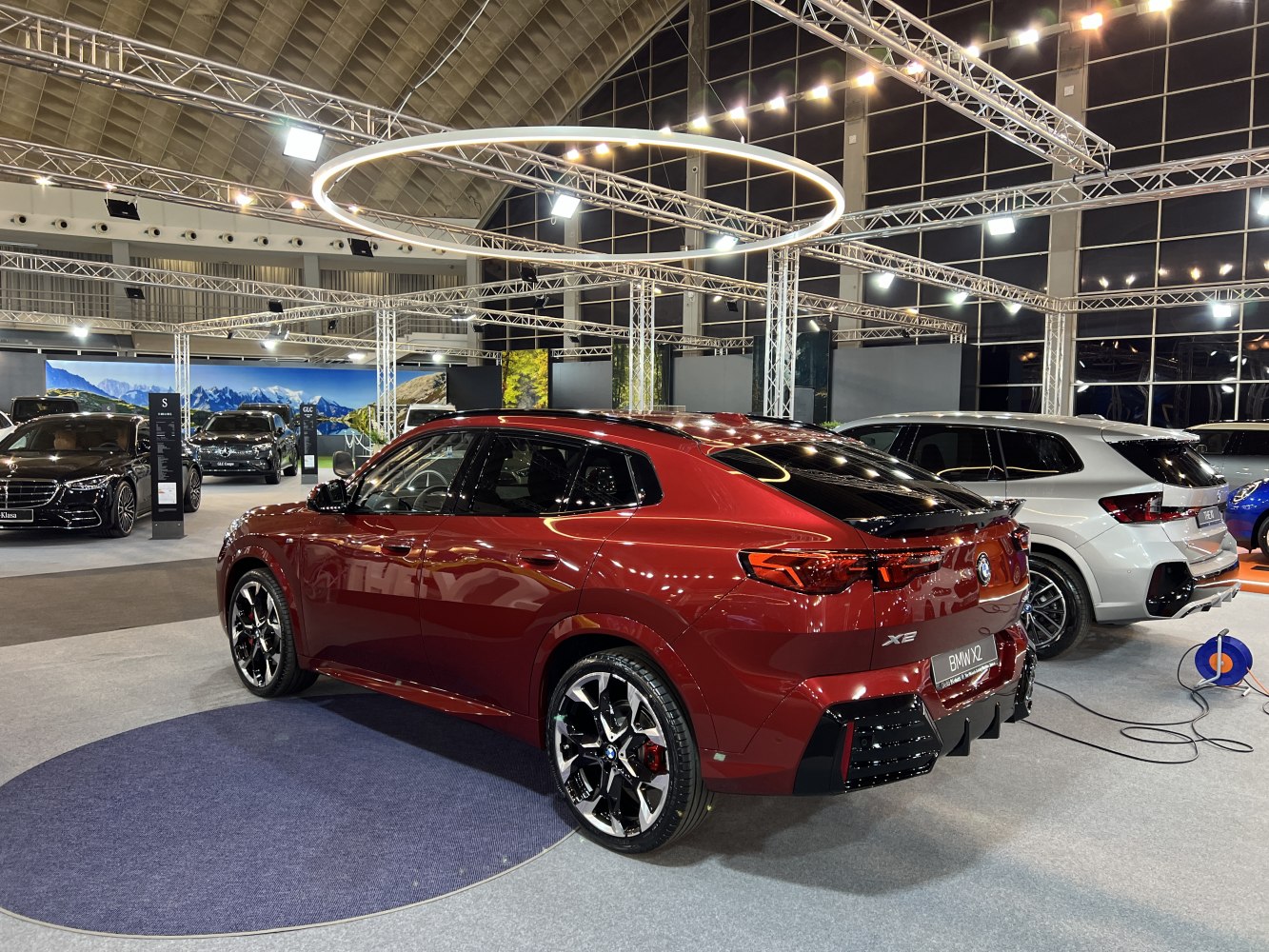 Rear and side view of sleek metallic red SUV with black alloy wheels.