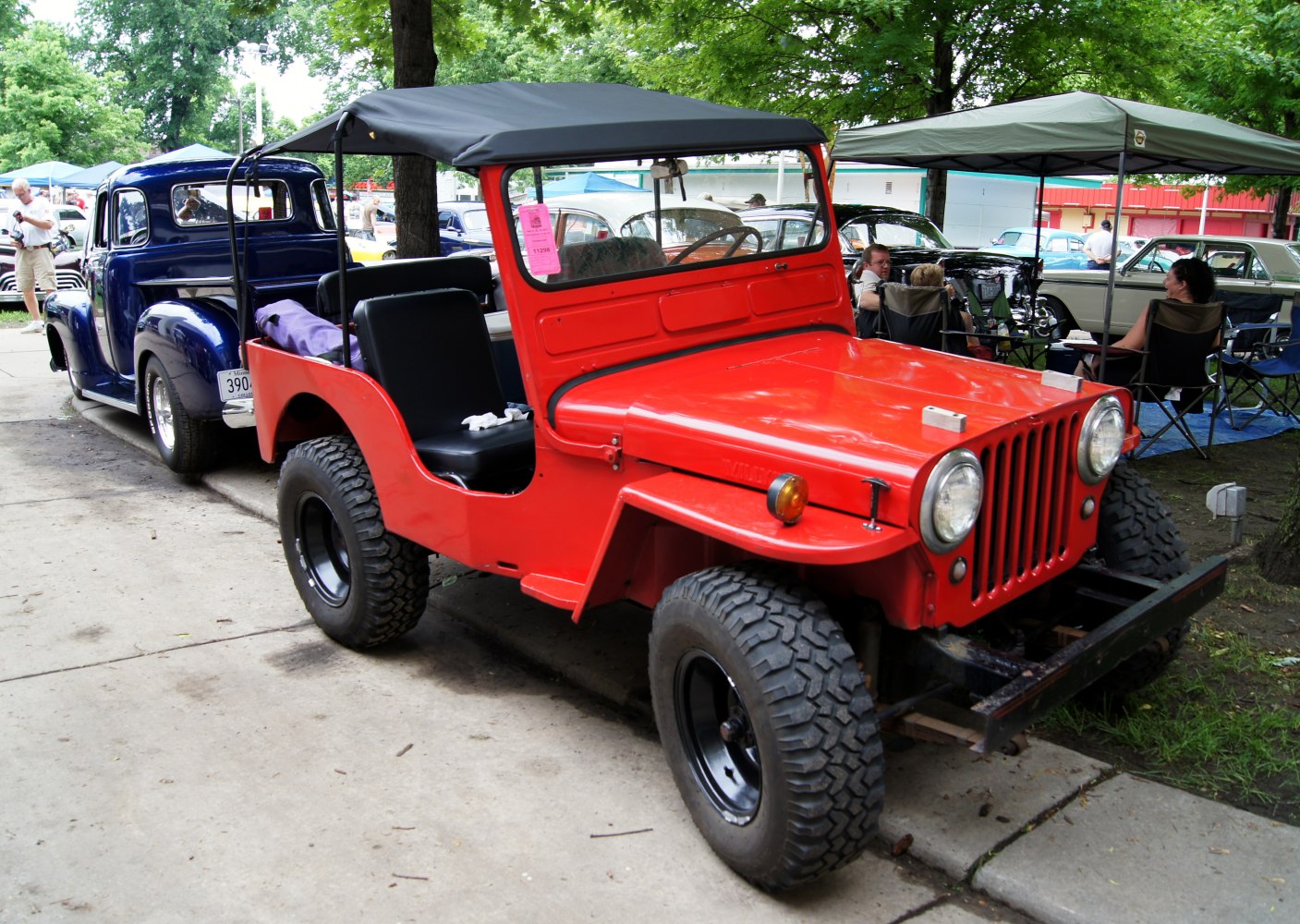 Open-top red off-road vehicle with canvas roof and rugged tires