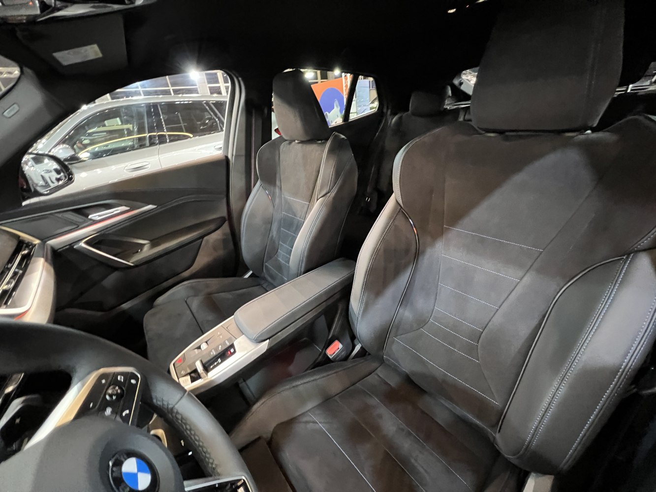 Modern black upholstery front seats with ergonomic design and control panel near armrest