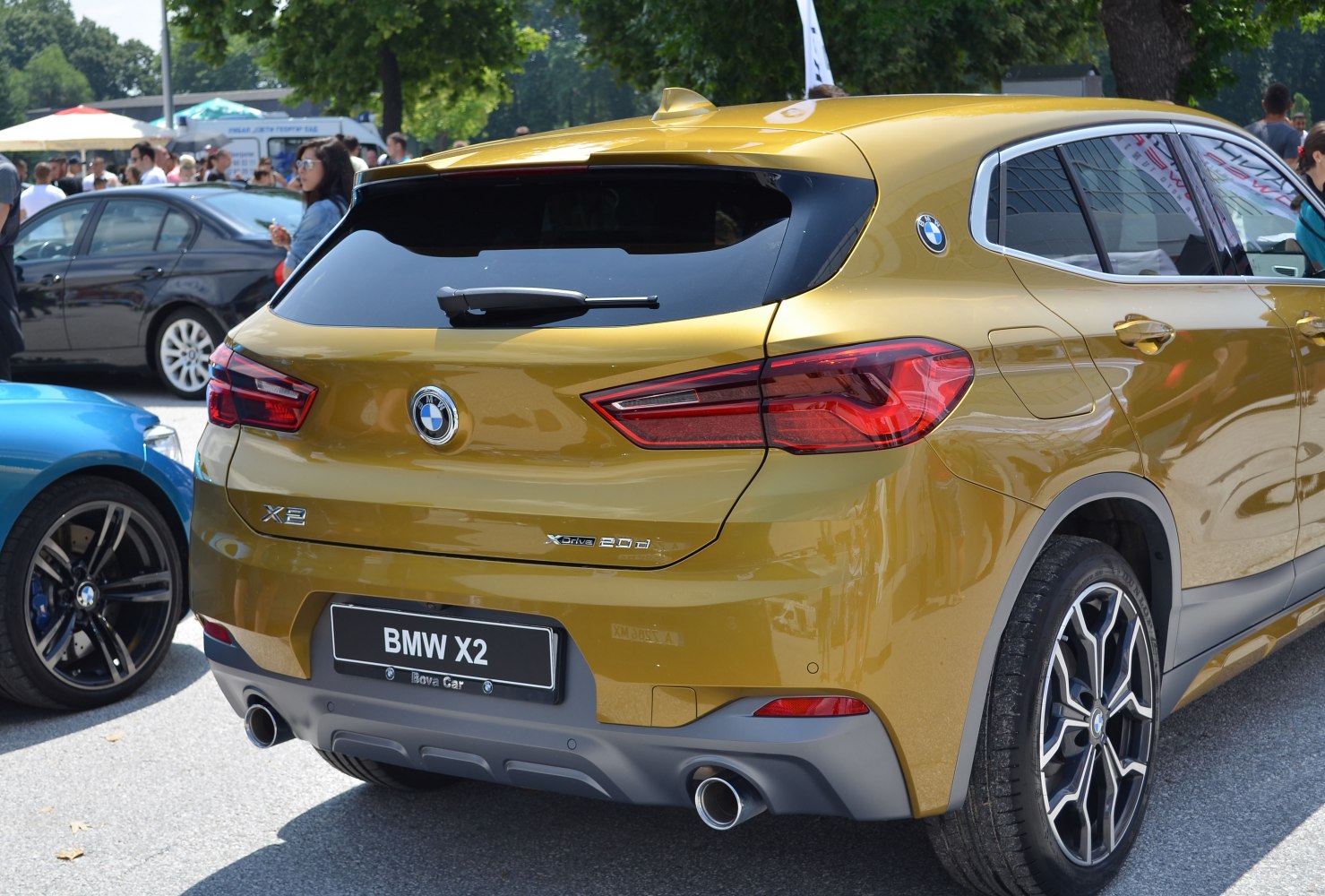 Rear view of metallic gold compact SUV with dual exhaust and modern taillights