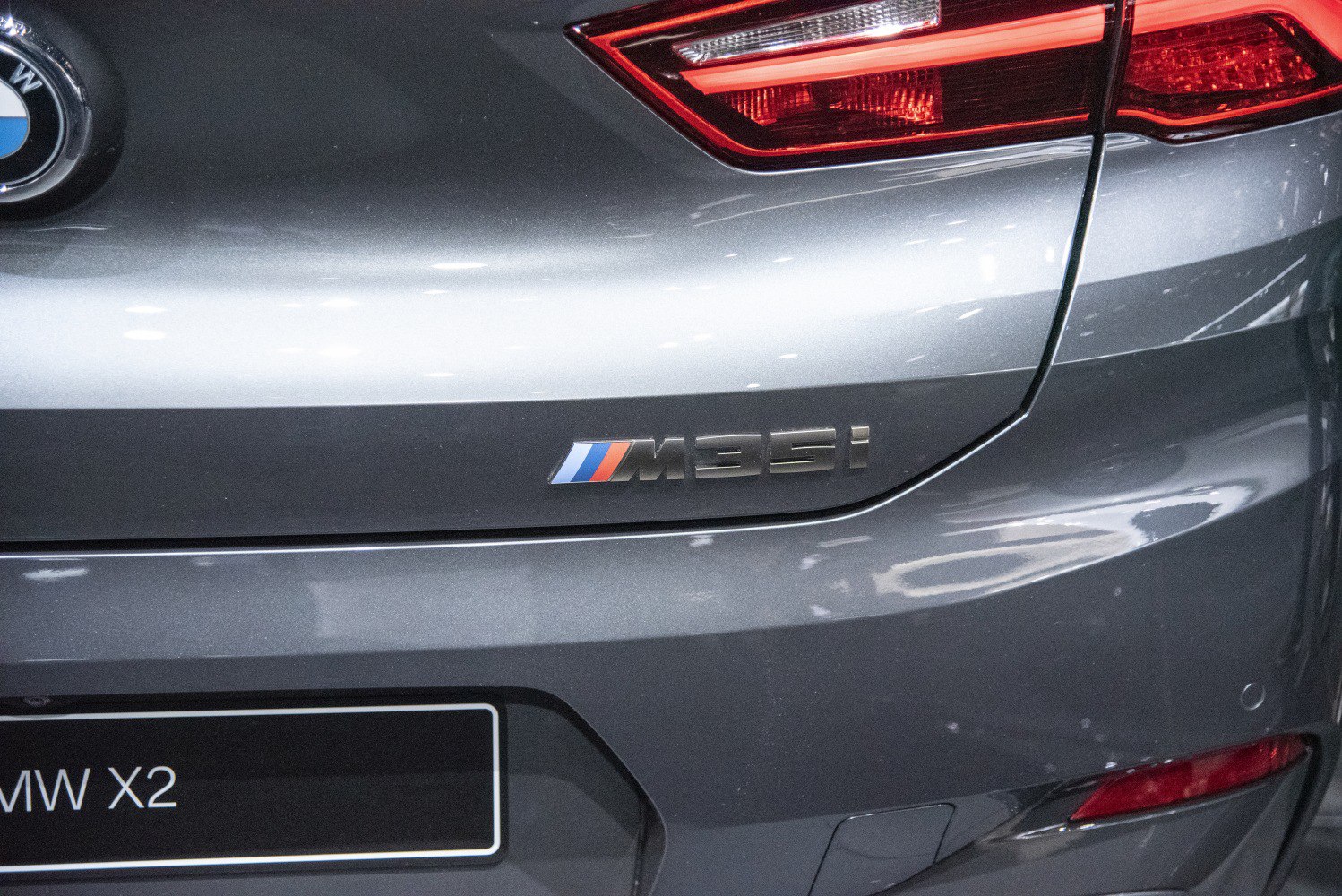 Close-up of M35i badge and rear taillight on a metallic gray surface
