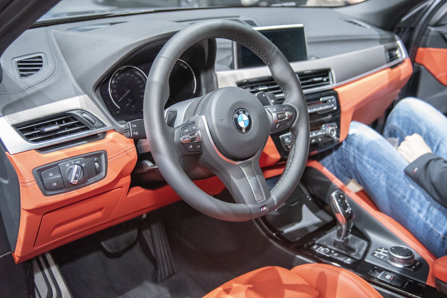 Steering wheel, dashboard, center console, and orange upholstery interior