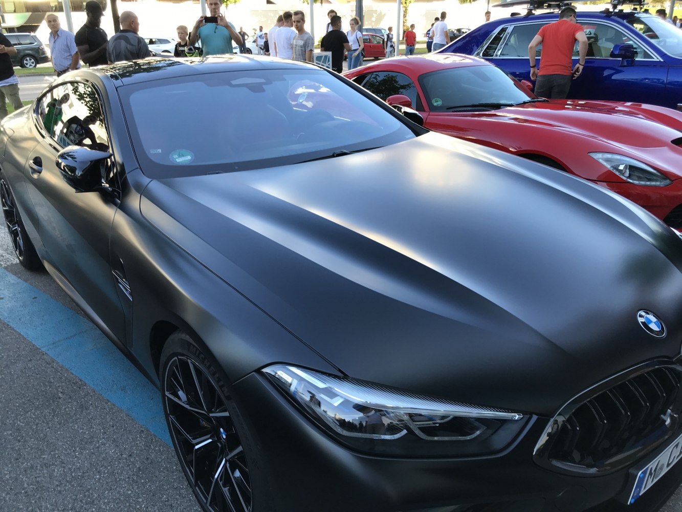 Matte black front view with sharp LED headlights and black wheels