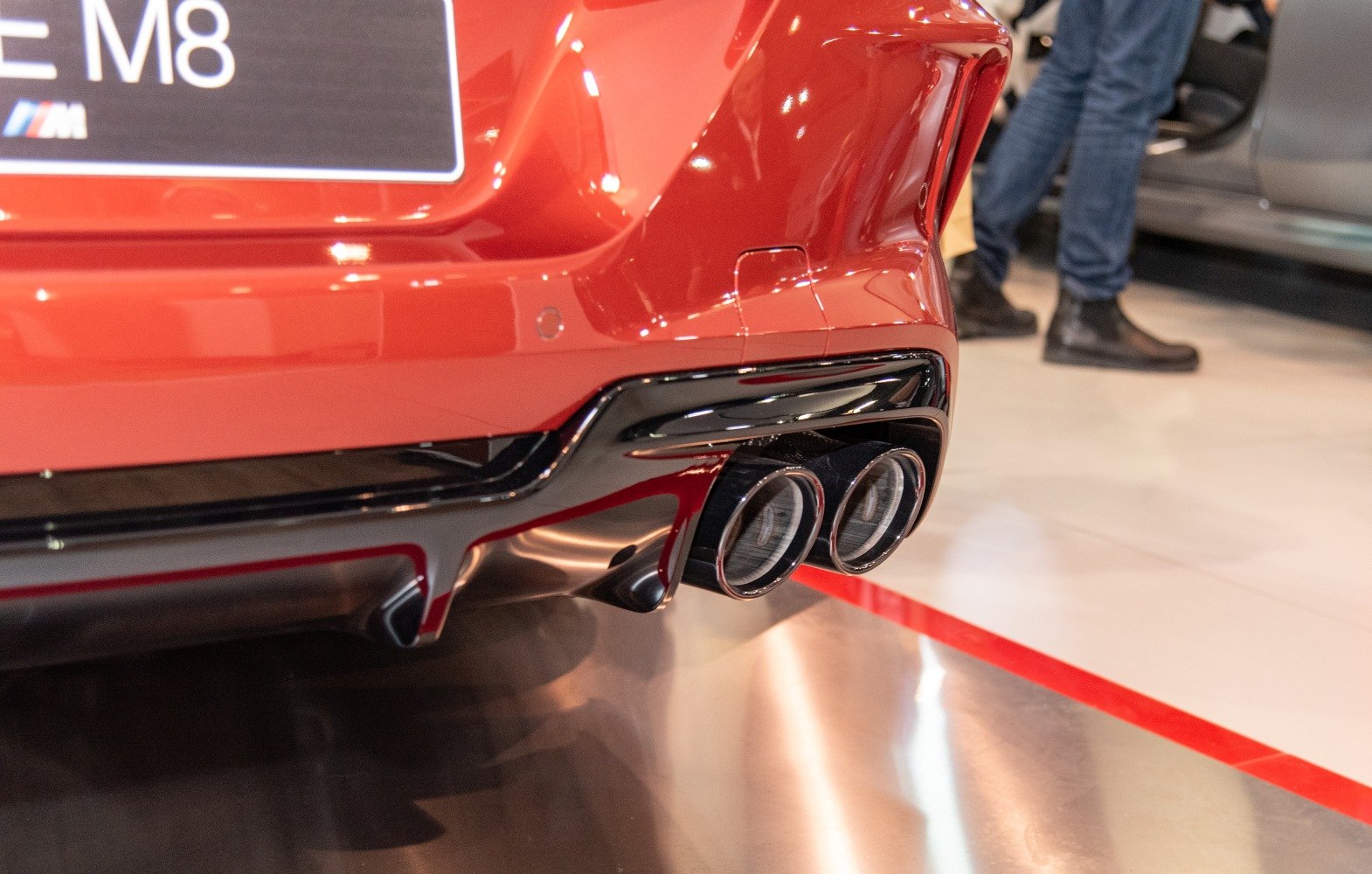Close-up of dual exhaust tailpipes and rear diffuser on a red sports car