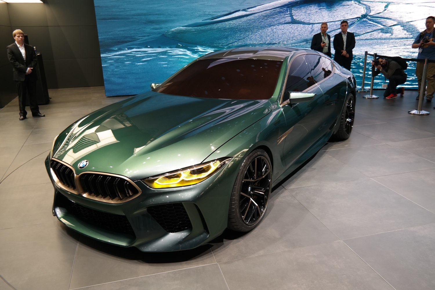 Sleek green sports sedan with yellow headlights and black alloy wheels
