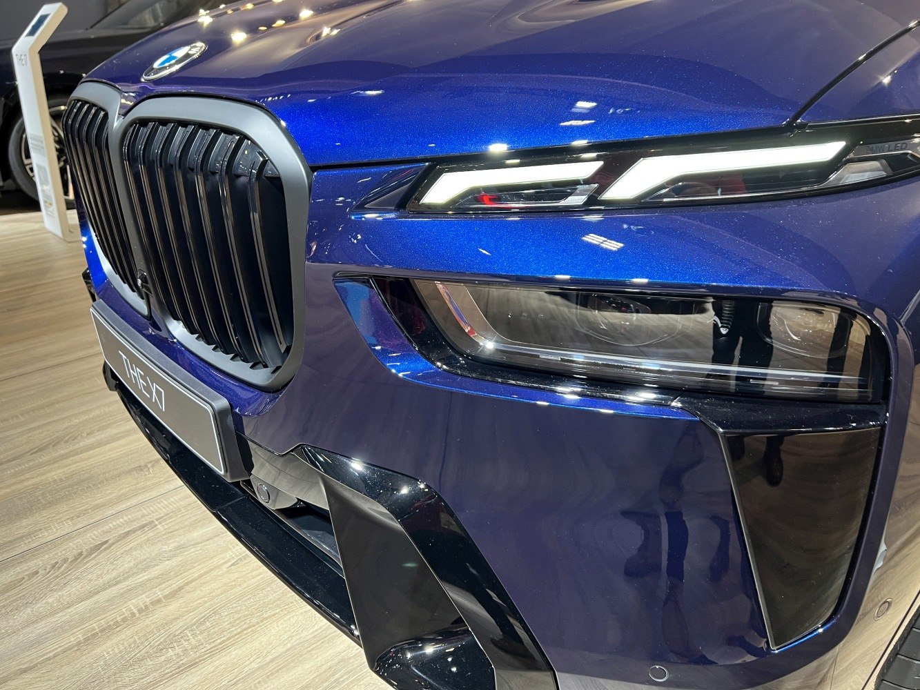 Close-up of front kidney grille and LED headlights in blue luxury SUV