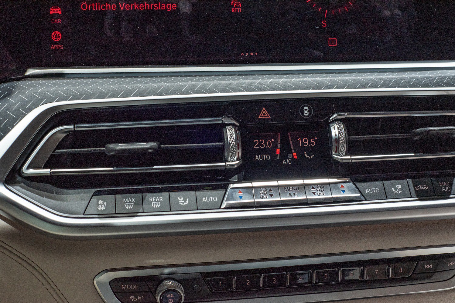 Close-up of dual-zone climate control panel with air vents and textured trim