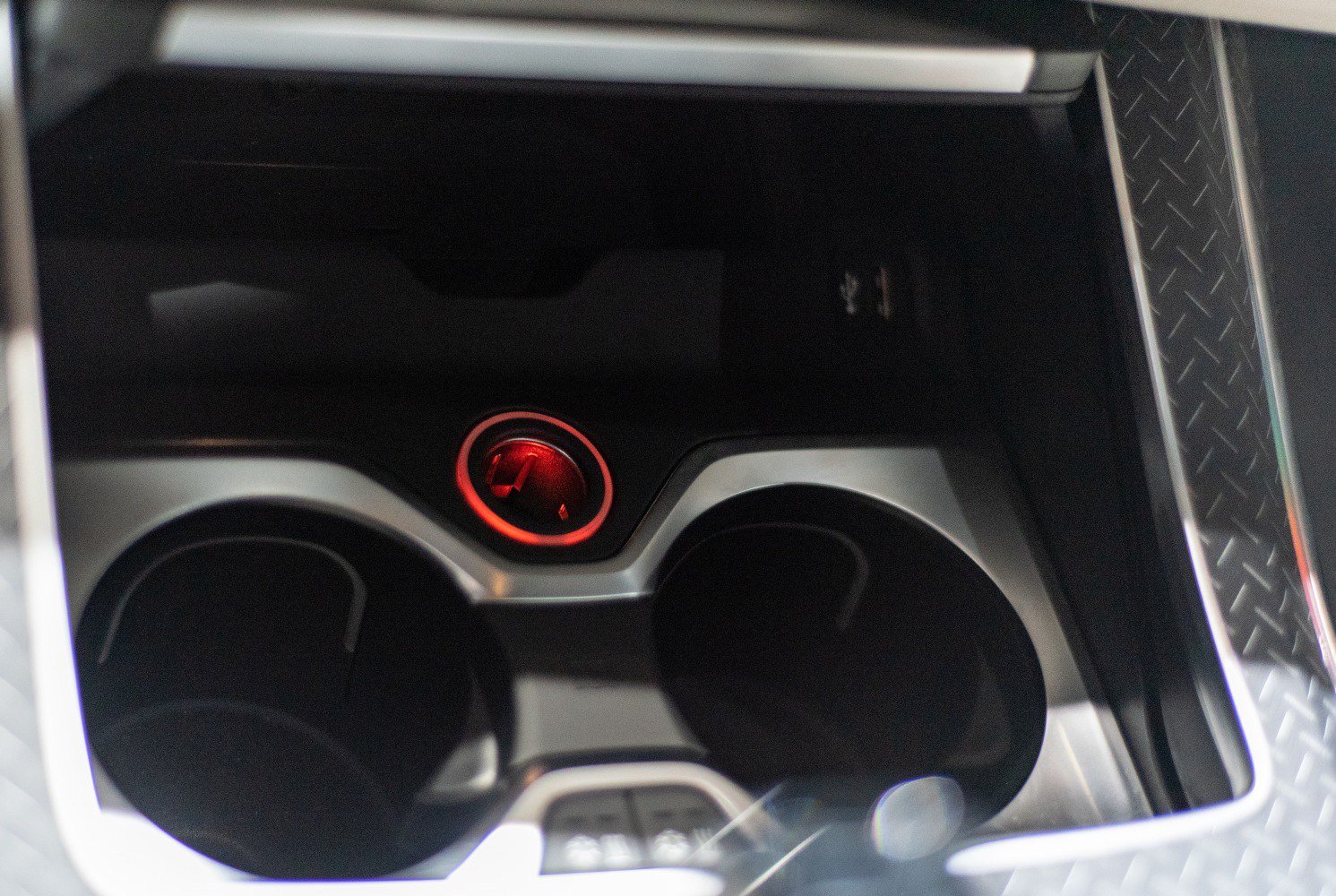 Cup holders and illuminated ignition start button in center console